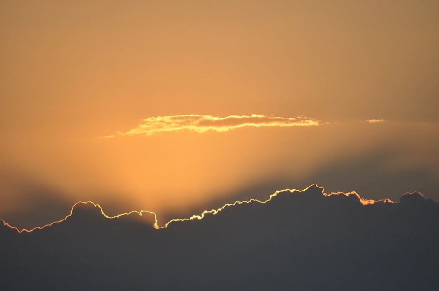 Golden Sunset Rays Illuminating Cloud Silhouette