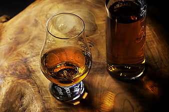 Whiskey Snifter and Bottle on Rustic Wooden Table