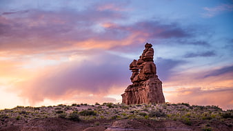 Dramatic rock formation silhouette against colorful sunset sky