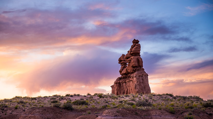 Dramatic rock formation silhouette against colorful sunset sky