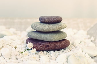Stacked Zen Stones on White Pebbles with Small White Flowers