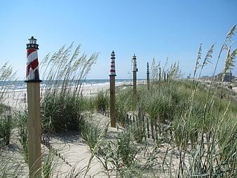 Miniature Lighthouses on Sandy Beach Dunes with Sea Grass