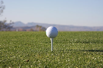 White Golf Ball on Tee with Mountain Background