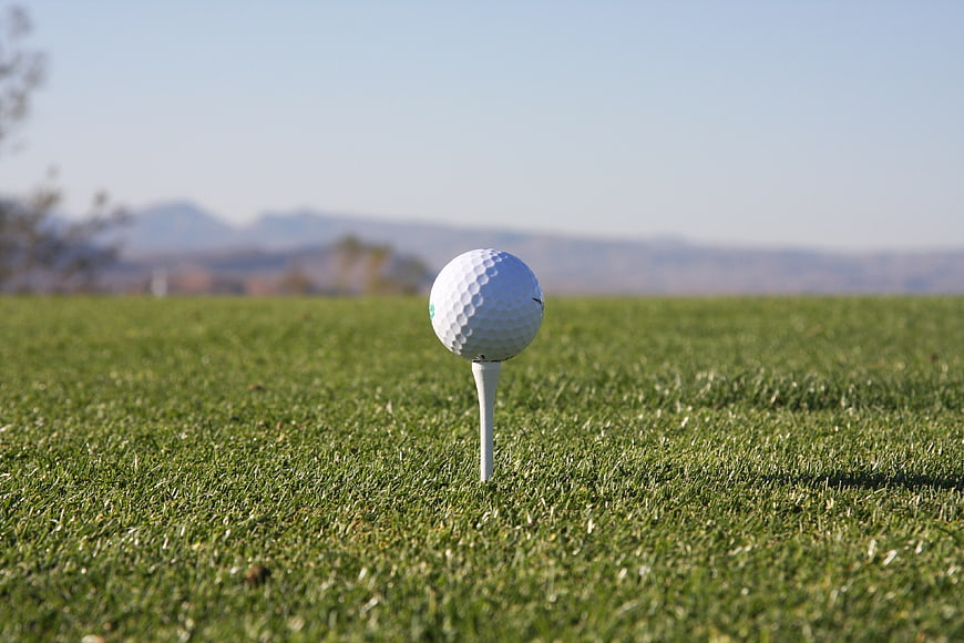 White Golf Ball on Tee with Mountain Background