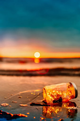 Glowing Mason Jar on Beach at Sunset