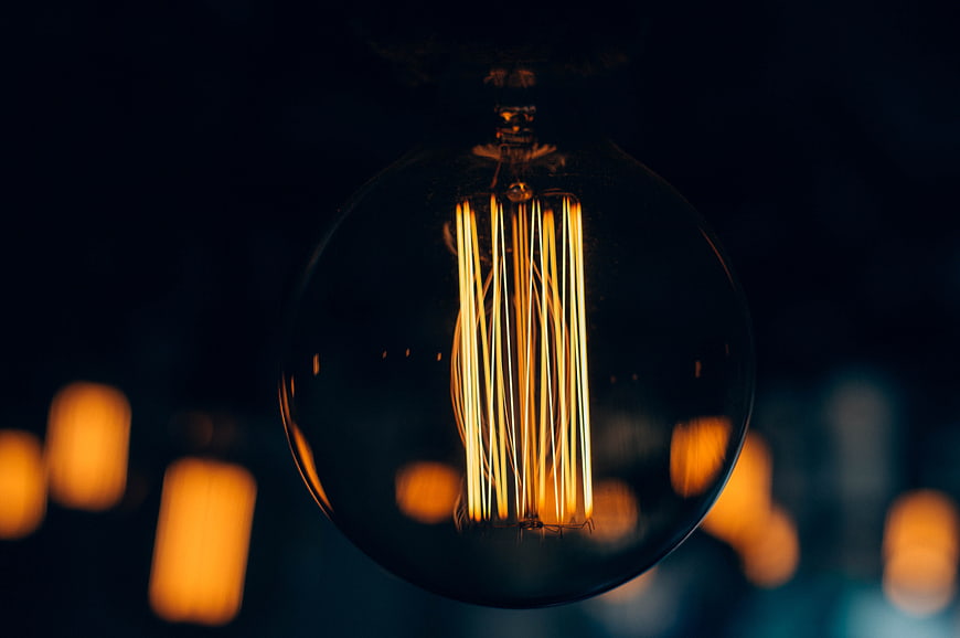 Vintage Edison Light Bulb with Glowing Filament in Dark Setting