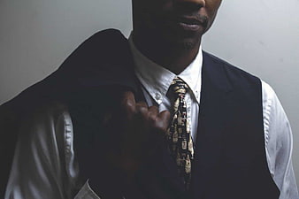Man in Vest and Patterned Tie Adjusting Jacket