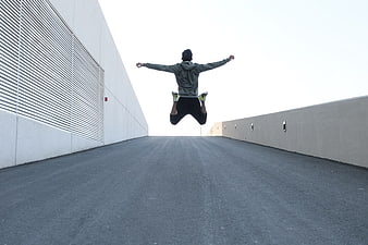Man Jumping in Mid-Air on Concrete Roadway