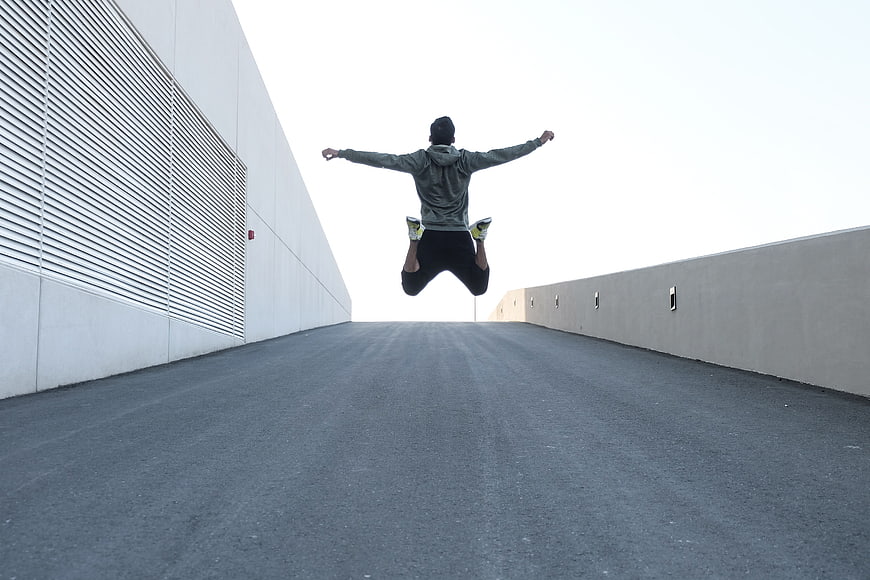 Man Jumping in Mid-Air on Concrete Roadway
