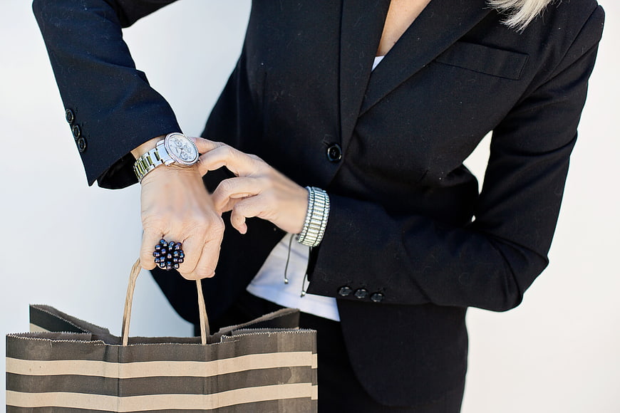 Business Woman Checking Watch While Holding Shopping Bag
