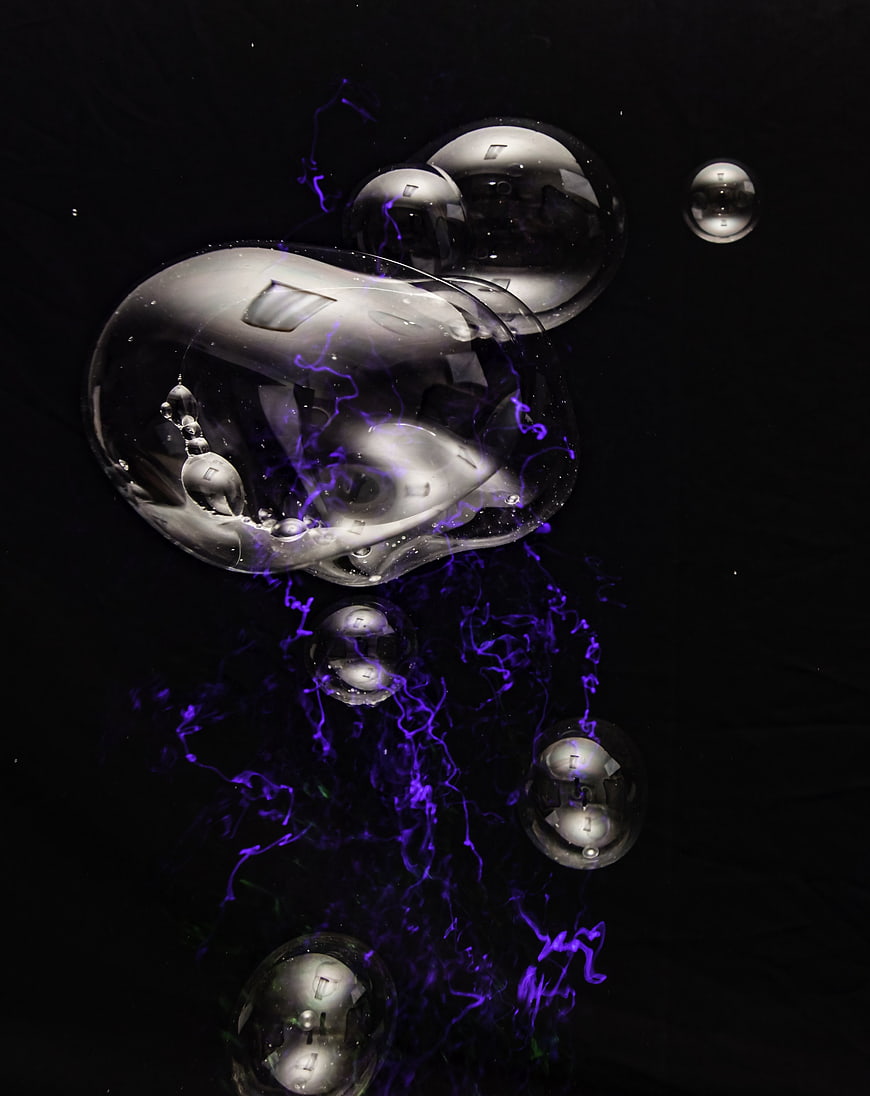 Abstract Soap Bubbles with Purple Smoke on Black Background