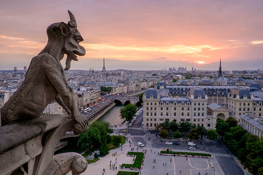 Gargoyle overlooking Paris skyline at sunset with Eiffel Tower