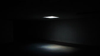Single skylight illuminating dark empty room interior