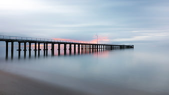 Long Exposure Serene Pier at Sunset Over Calm Ocean