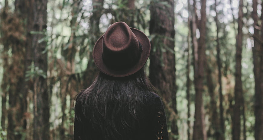 Woman in Brown Hat Standing in Misty Forest