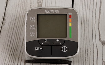 Digital Blood Pressure Monitor on White Wooden Background