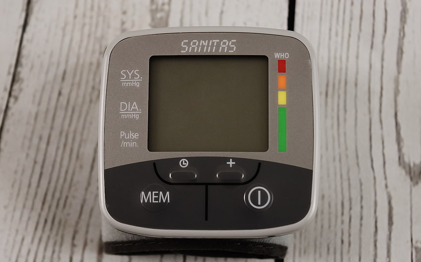 Digital Blood Pressure Monitor on White Wooden Background