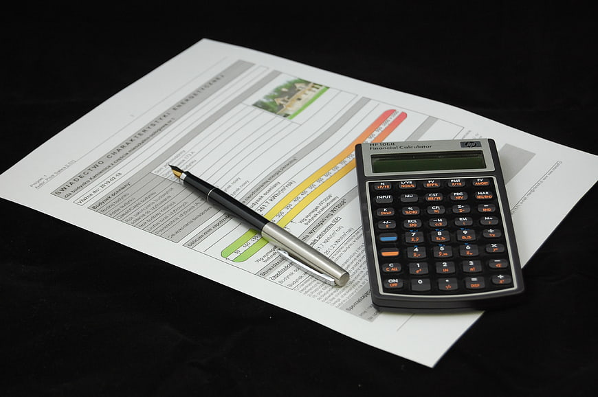 Financial Calculator And Pen On Real Estate Energy Certificate Document