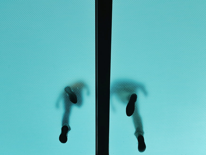 Silhouette of feet walking on frosted glass