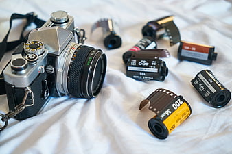 Vintage film camera and rolls of 35mm film on white cloth