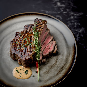 Gourmet grilled steak with rosemary and sauce on ceramic plate