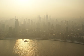 Hazy Golden Cityscape Skyline Over River at Sunset