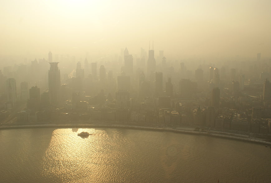 Hazy Golden Cityscape Skyline Over River at Sunset