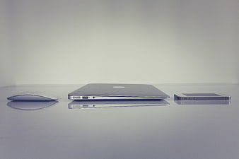 Minimalist Apple Laptop, Mouse, and Smartphone Arrangement on White Surface
