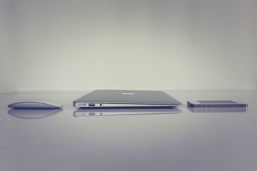 Minimalist Apple Laptop, Mouse, and Smartphone Arrangement on White Surface