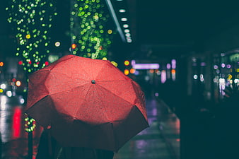 Red Umbrella in Rainy City Night with Bokeh Lights