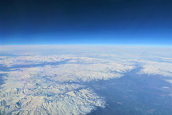Aerial View of Snow-Covered Mountain Range Under Blue Sky
