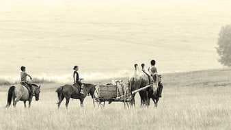 Mongolian family on horseback and camel cart in steppe landscape