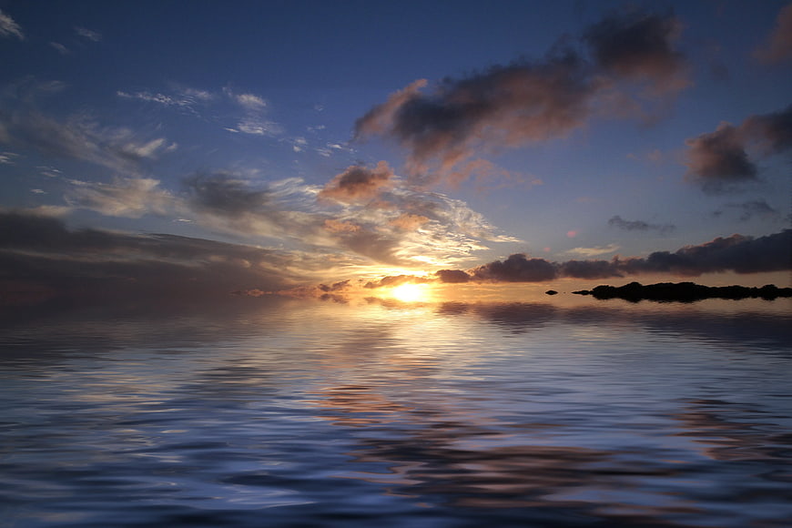 Serene Sunset Over Calm Ocean with Distant Island Silhouette