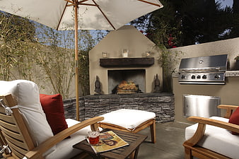 Cozy outdoor patio with fireplace, grill, and lounge seating
