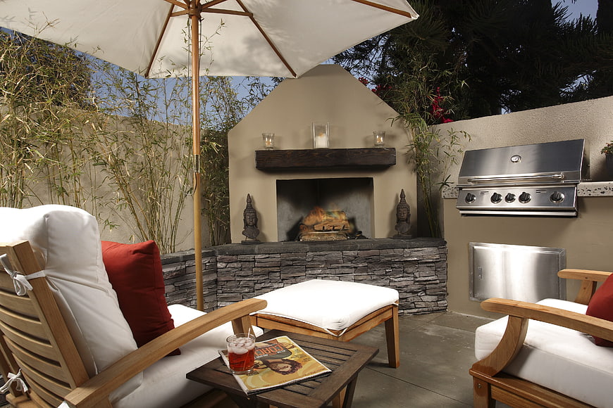 Cozy outdoor patio with fireplace, grill, and lounge seating