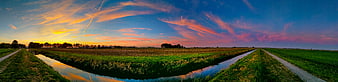 Panoramic sunset over Dutch polder landscape with canal