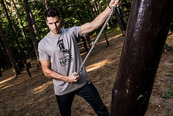 Athletic Man Pulling Rope in Forest Workout