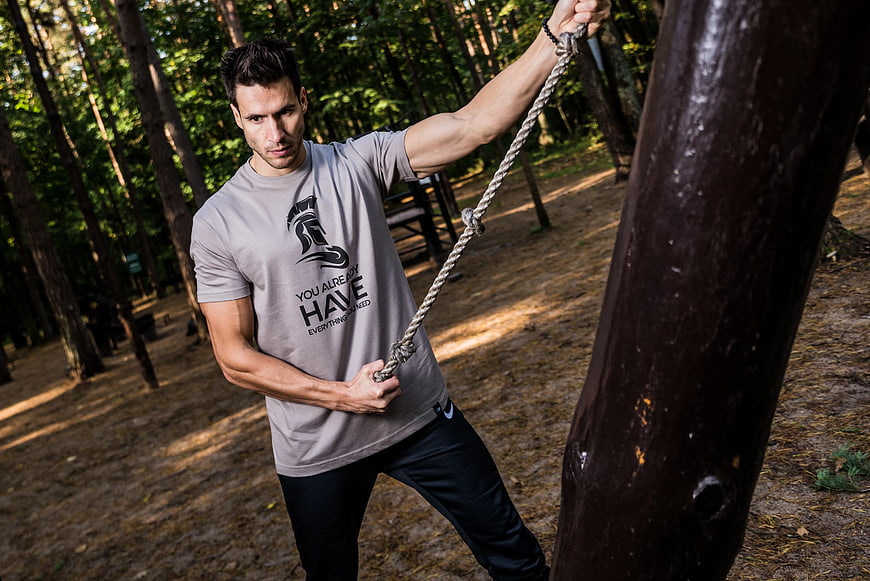 Athletic Man Pulling Rope in Forest Workout