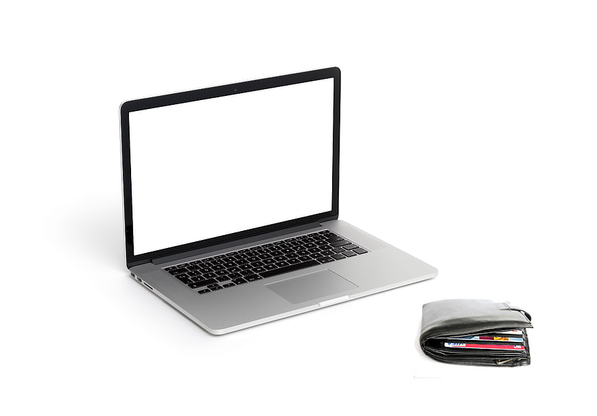 Laptop with blank screen and wallet with credit cards on white background