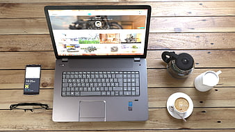 Top view of laptop workspace with coffee and smartphone on wooden desk