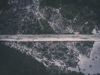 Aerial view of white van on snowy forest road