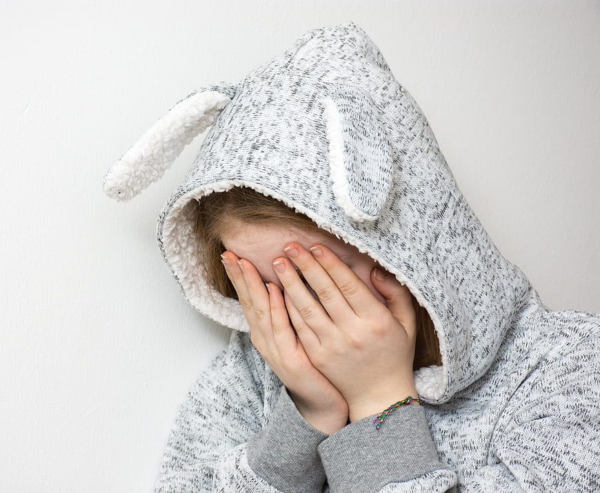 Sad Teenage Girl Hiding Face in Bunny Hoodie