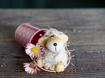 Cute handmade wooden sheep figurine with daisies in pink cup