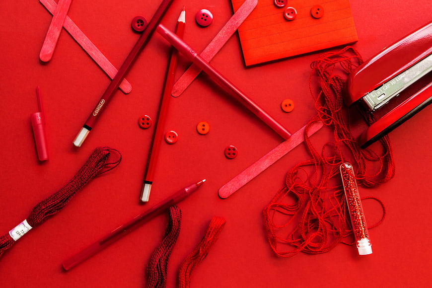 Red Stationery Flat Lay with Pens, Buttons, and Thread