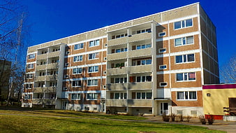Modern brick apartment building with balconies on sunny day
