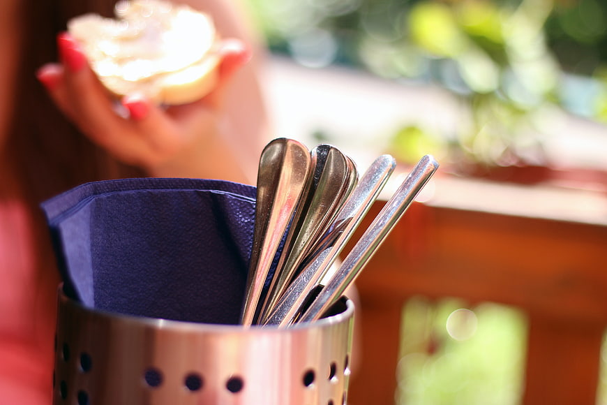 Close-up of silverware in metal holder with blurred background