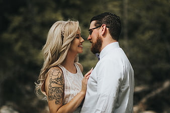 Happy couple with tattoo smiling outdoors in nature
