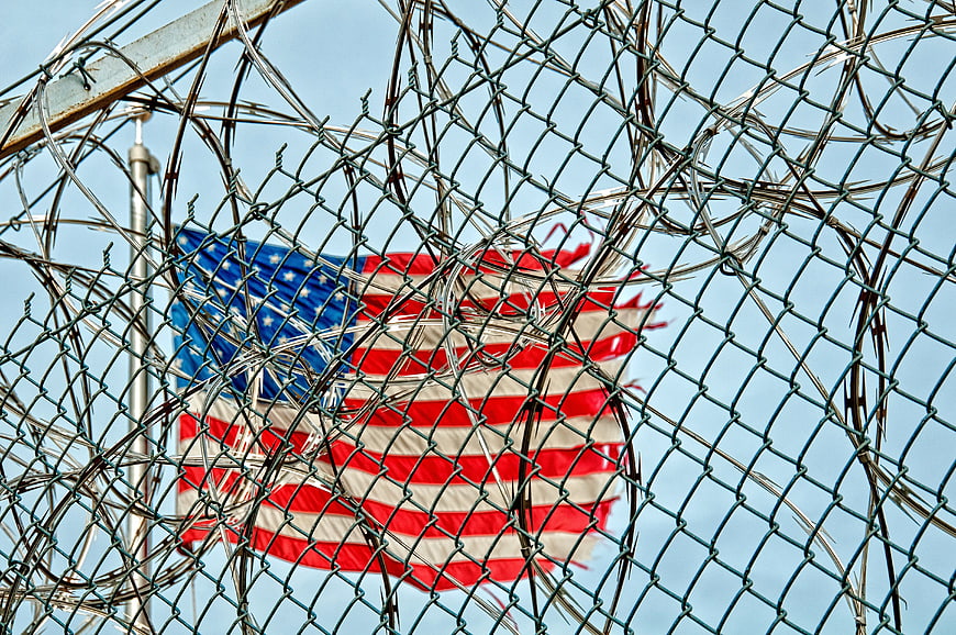 American Flag Behind Barbed Wire Fence