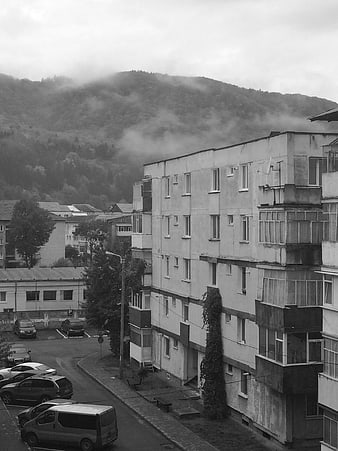 Black and white view of apartment block with foggy mountain background