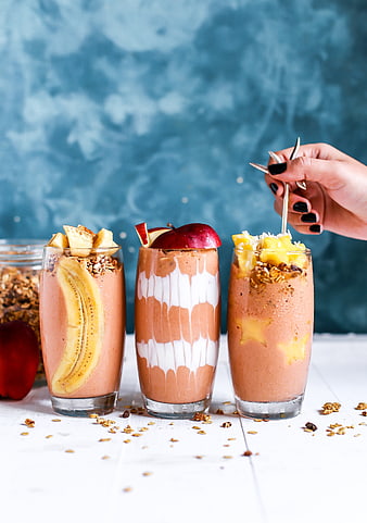 Three Healthy Fruit Smoothies with Granola and Fresh Toppings